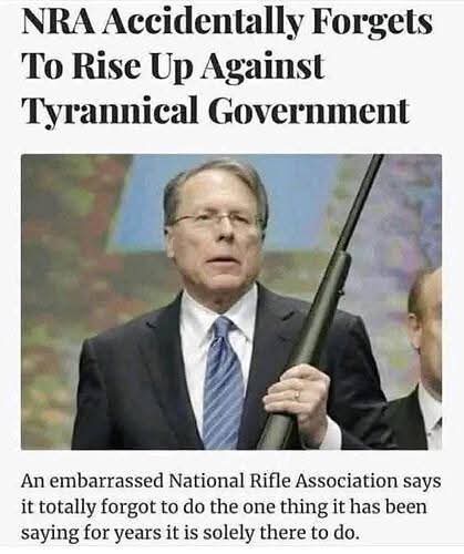 A man in a suit and tie holding a rifle stands in front of a blurred background. Overlaid text reads 'NRA Accidentally…