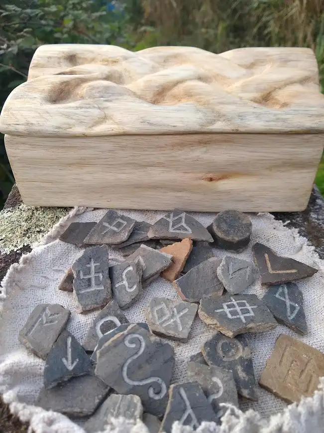 A one-of-a-kind hand-carved wooden box featuring Roman pottery designs etched into rune stones.