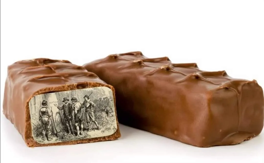 A chocolate bar is broken in half, revealing a vintage black-and-white illustration of men in historical attire inside the…
