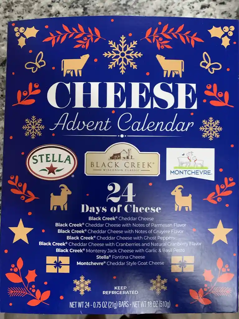 A blue cheese advent calendar box decorated with gold and red holiday motifs like snowflakes, holly, and goats. It lists 24…