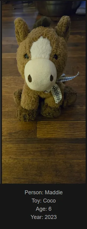A brown plush horse toy with a white blaze on its face and a plaid ribbon around its neck sits on a wooden floor. Text…
