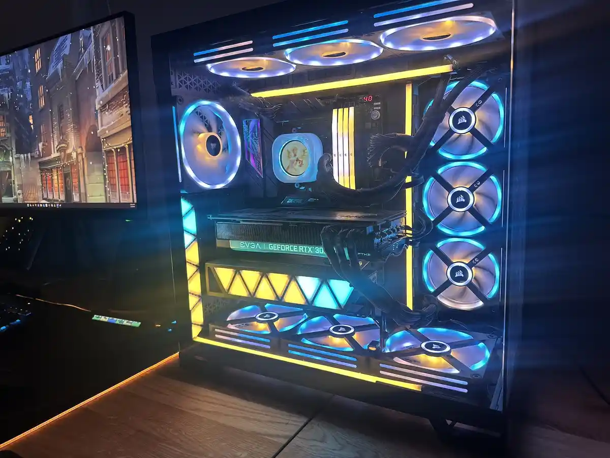 A custom-built gaming PC with a transparent case, glowing blue and yellow LED fans, and a visible GeForce RTX 3080 graphics…