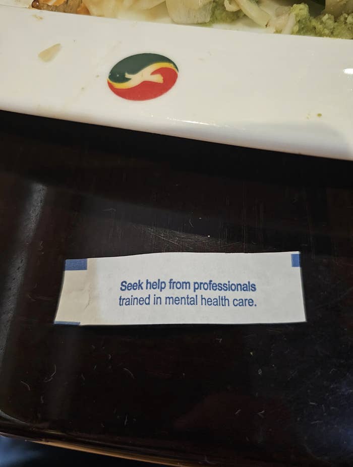 A close-up photo shows a fortune cookie slip with the text 'Seek help from professionals trained in mental health care.'…