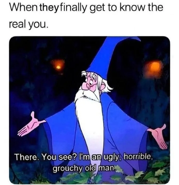 A cartoon wizard with a long white beard and blue robe stands with arms outstretched in a dark forest, looking…