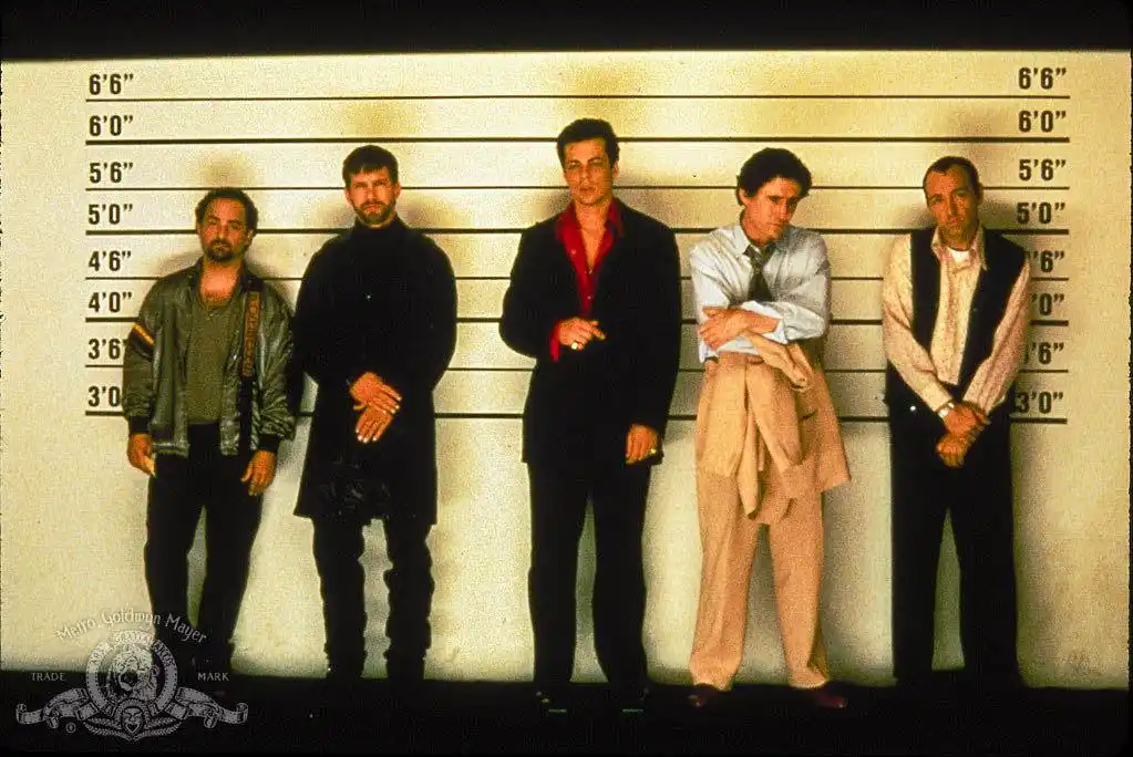 five men stand in a police lineup against a height chart, dressed in varied 1980s attire including jackets, suits, and…