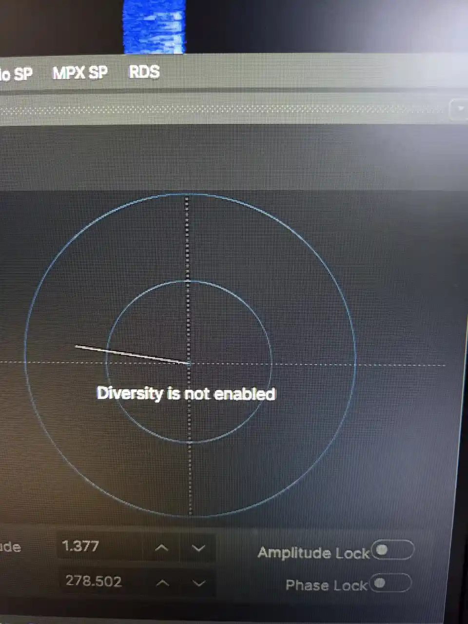 A close-up of a radio signal analyzer screen showing concentric circles and crosshairs, with the text 'Diversity is not…