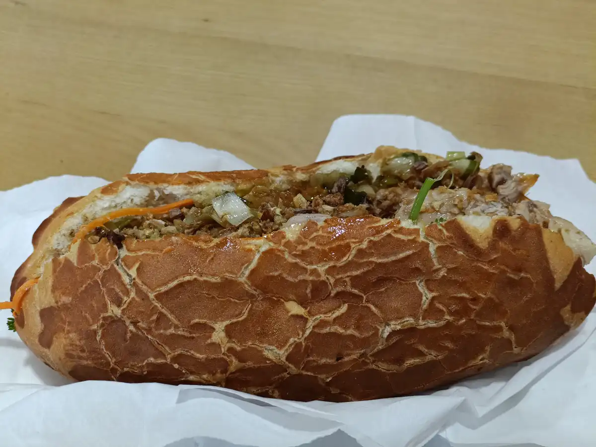 A close-up photo shows a sandwich with a crusty, golden-brown bread that has a distinct giraffe-like pattern of irregular…