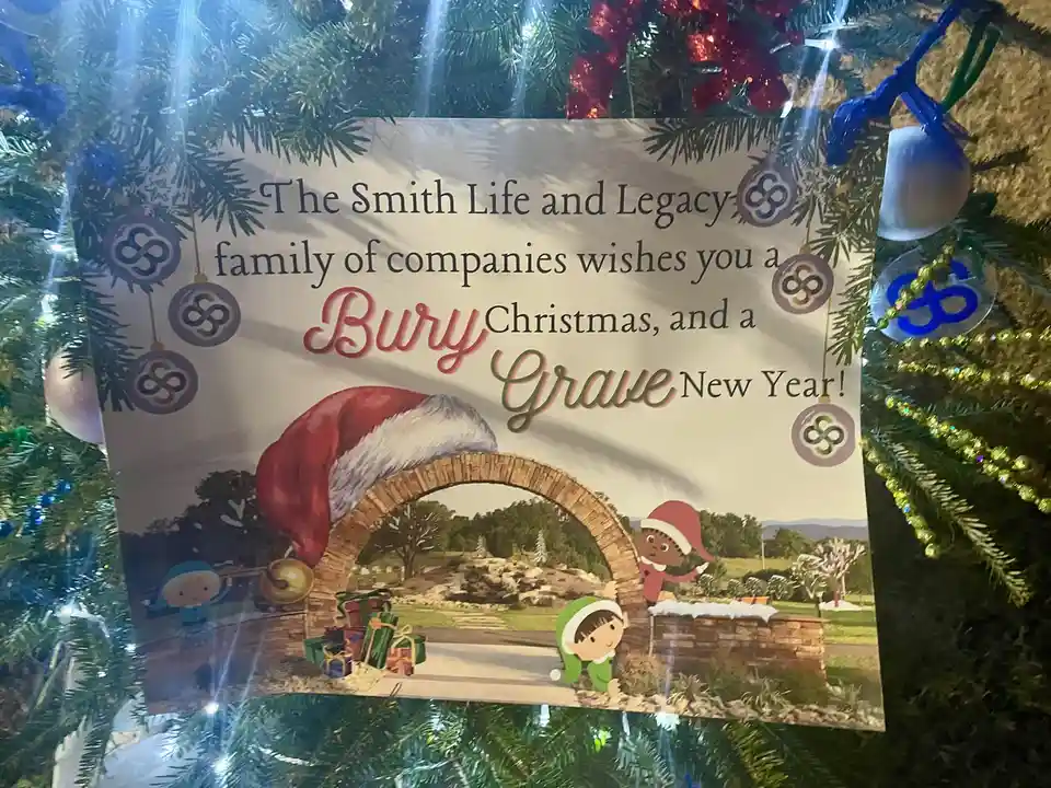 A Christmas card from 'The Smith Life and Legacy family of companies' is displayed on a decorated tree, featuring cartoon…