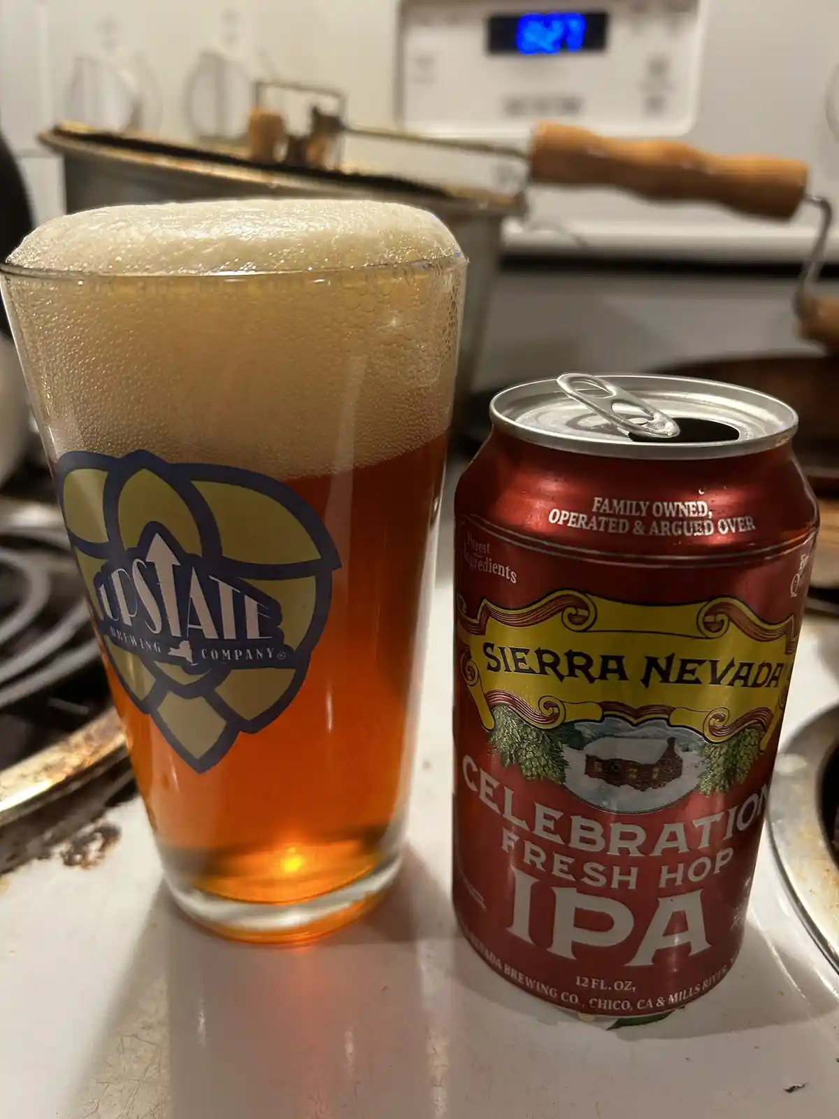 A can of Sierra Nevada Celebration Fresh Hop IPA sits next to a pint glass filled with amber beer and a thick, frothy head…