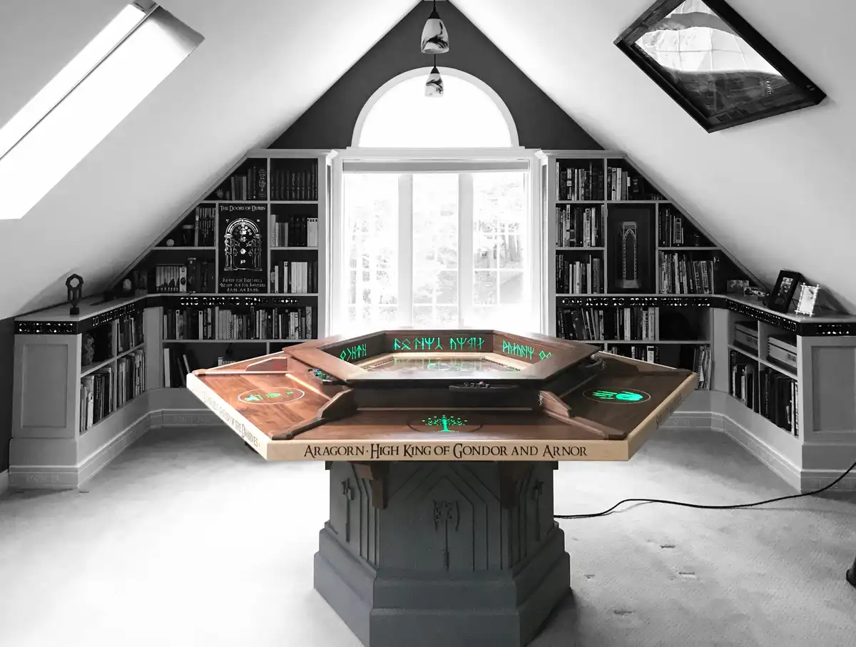 A black-and-white photo of a custom-built, octagonal game table in a room with bookshelves, featuring glowing green elvish…