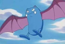 A blue bat-like Pokémon named Golbat with purple wings is flying against a blue sky with white clouds. The image has no…