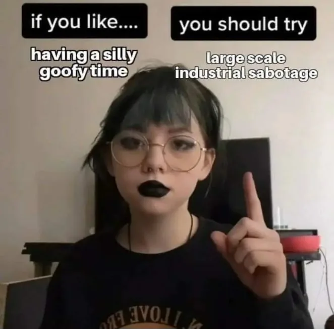 A young woman with dark lipstick and round glasses points her index finger upward while looking directly at the camera. Text…