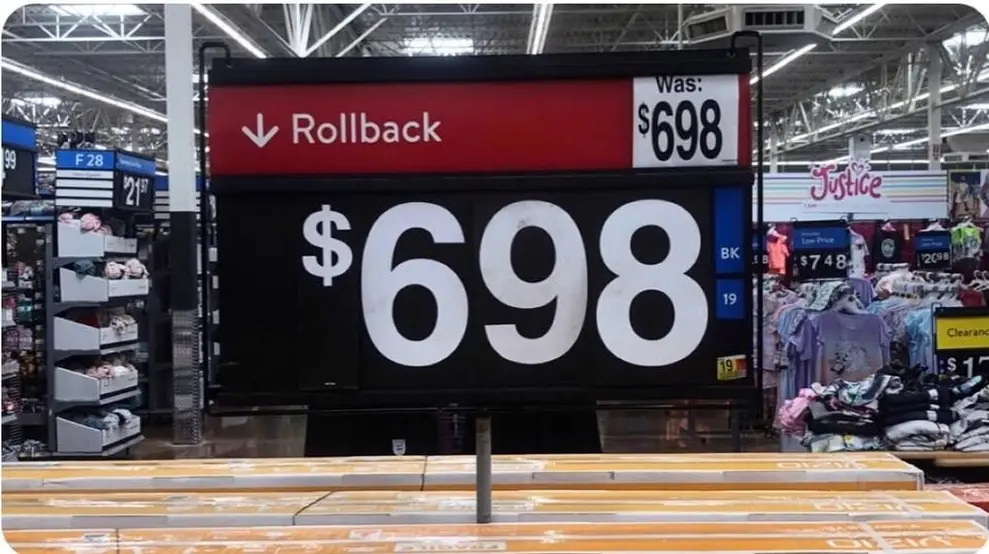 A large price sign in a retail store shows a rollback sale with the original price and the new sale price both listed as…