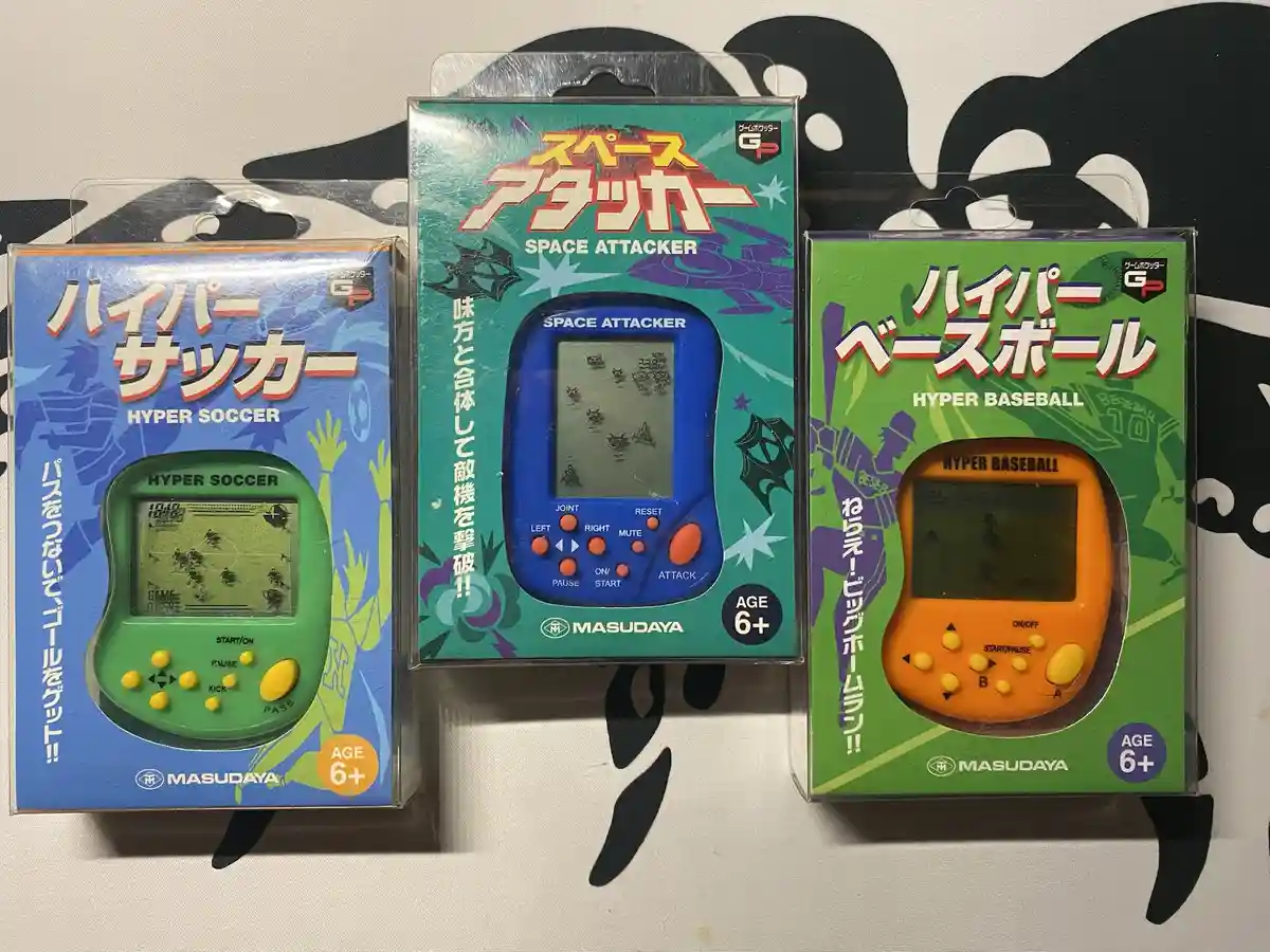 Three Japanese handheld game cartridges in their original packaging are displayed side-by-side: 'Hyper Soccer' (green)…