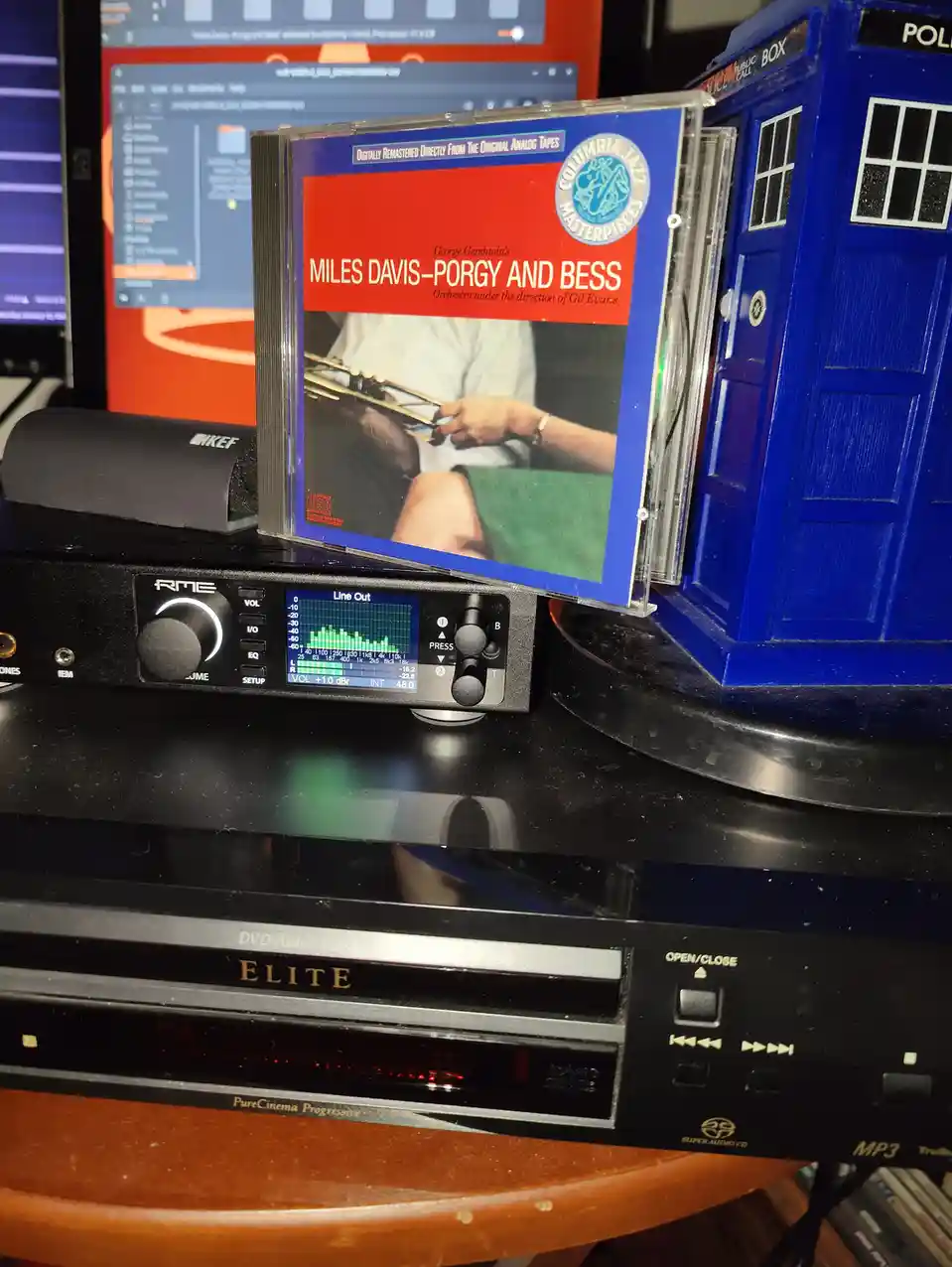 A Miles Davis 'Porgy and Bess' CD sits on top of an RME audio interface, next to a blue Doctor Who TARDIS model and a…