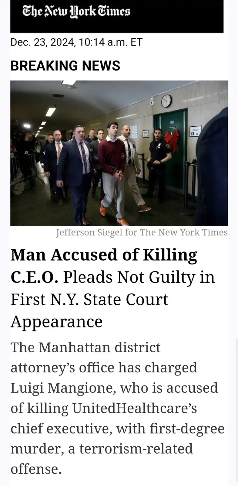 A screenshot of a New York Times breaking news article from Dec. 23, 2024, showing a man in a maroon sweater and orange…
