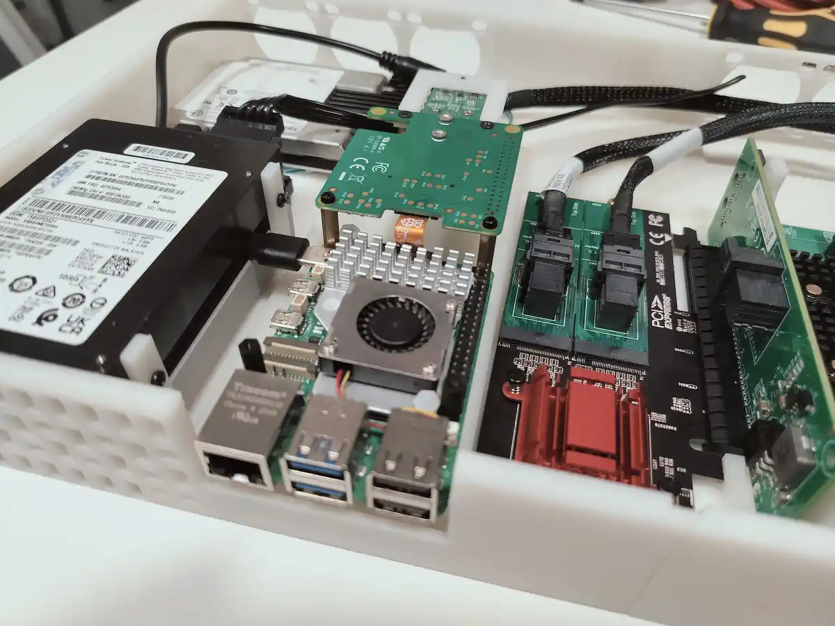 A close-up photo of a custom-built computer case filled with various computer components including a Raspberry Pi with a fan…