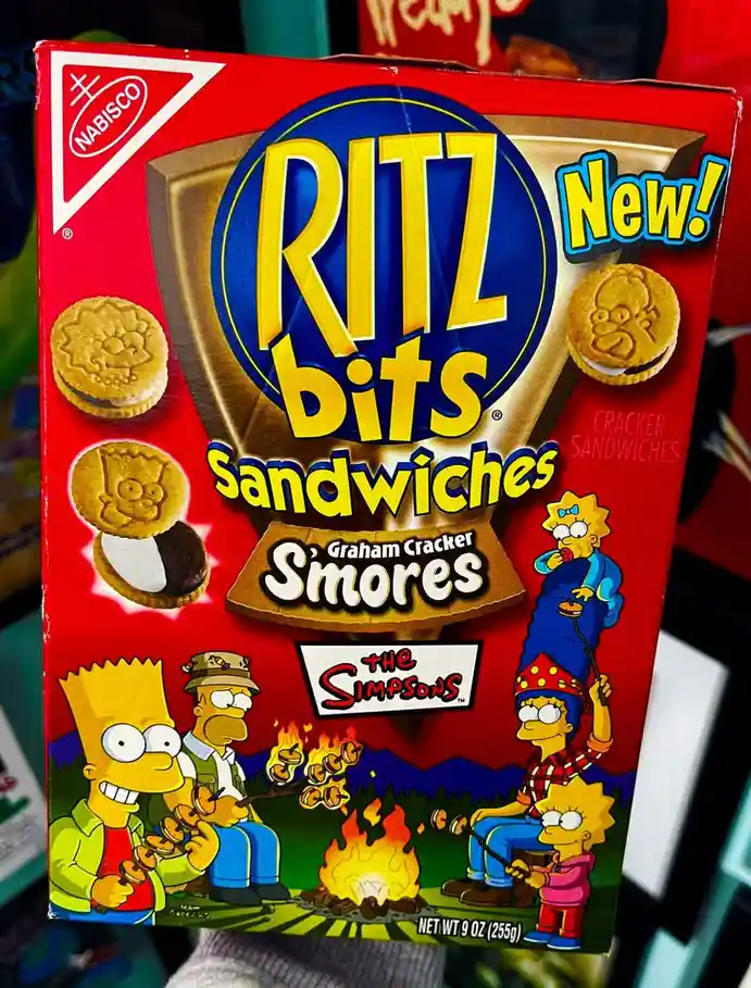 A red box of Nabisco Ritz Bits Graham Cracker S'mores sandwiches, featuring The Simpsons characters camping around a…