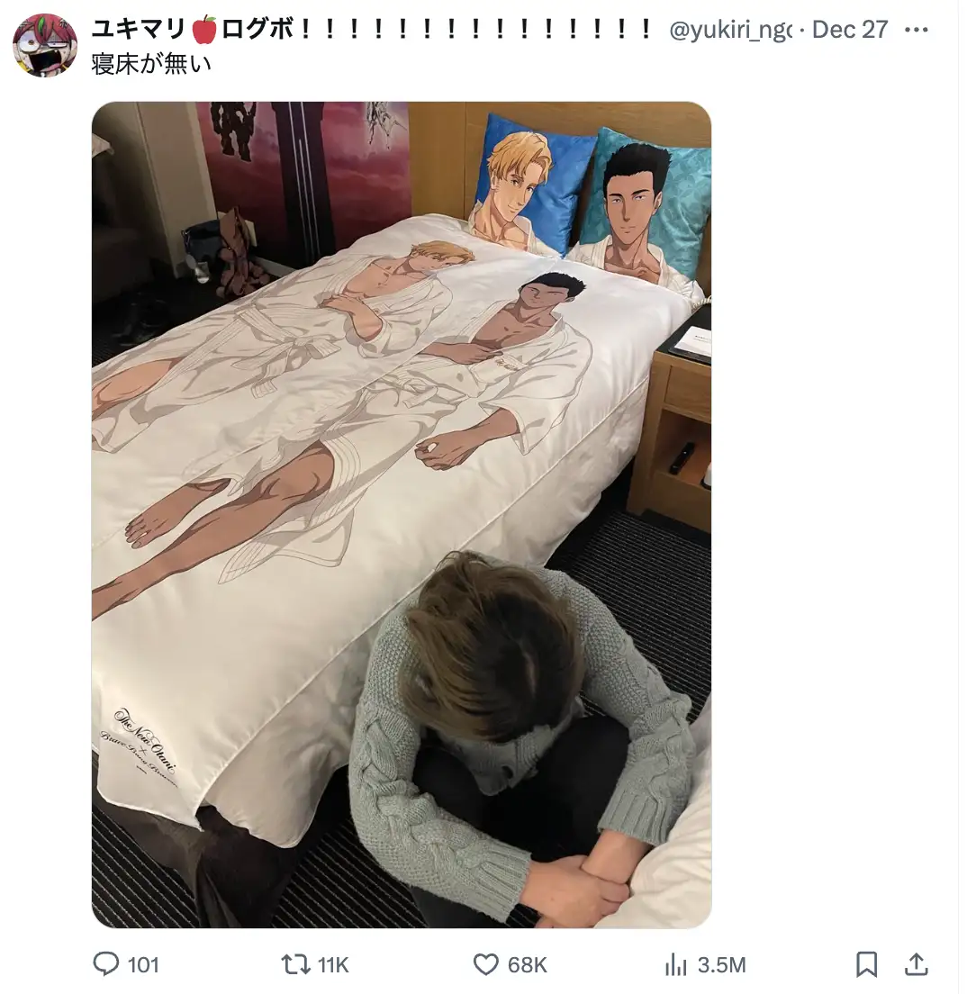 A person is sitting on the floor in front of a bed, head bowed in apparent despair, while the bed is covered with a duvet…