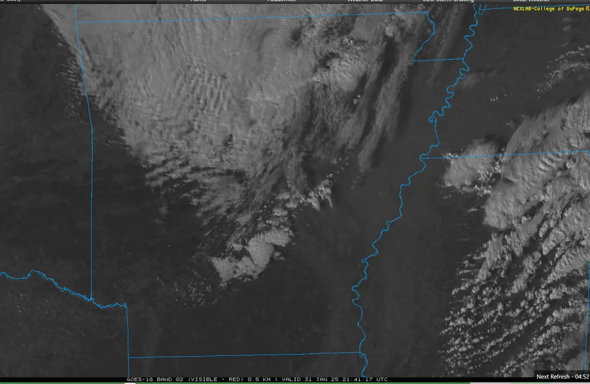 A grayscale satellite weather image shows a large, textured storm system over land, outlined in blue. The overlaid text…