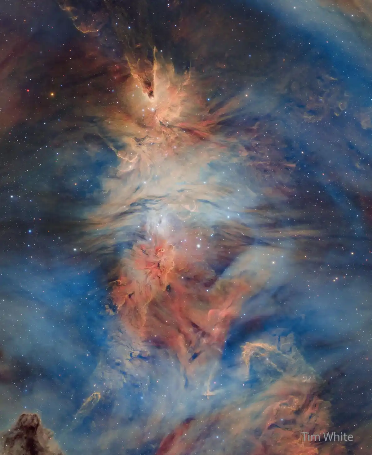 A stunning astronomical photograph of a colorful nebula filled with swirling clouds of gas in shades of blue, orange, and…
