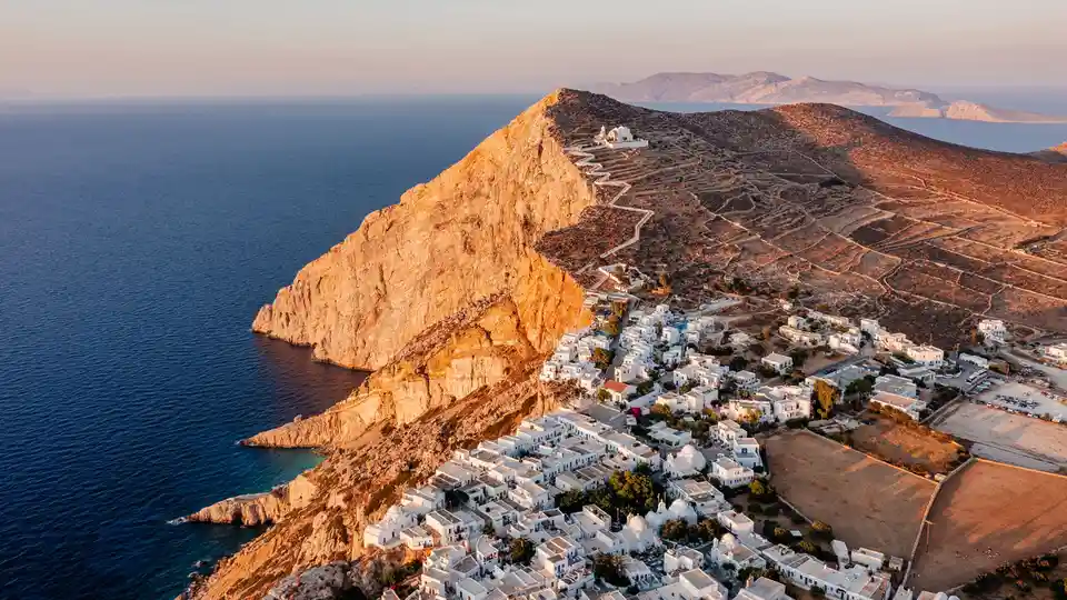 On a serene isle, chalk-hued villages cling to steep cliffs, surrounded by sun-kissed white sand and crystal-clear waters…