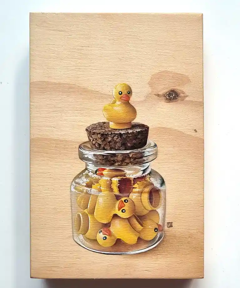 A painting depicts a glass jar filled with broken yellow rubber ducks, with one intact duck perched on the cork lid. The jar…
