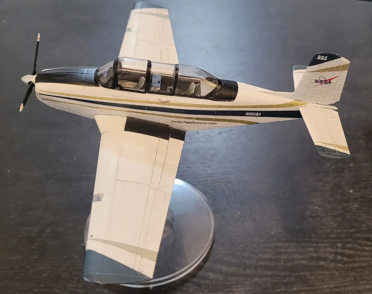A detailed model of a small propeller airplane, painted in NASA livery with "Dryden Flight Research Center" and registration…