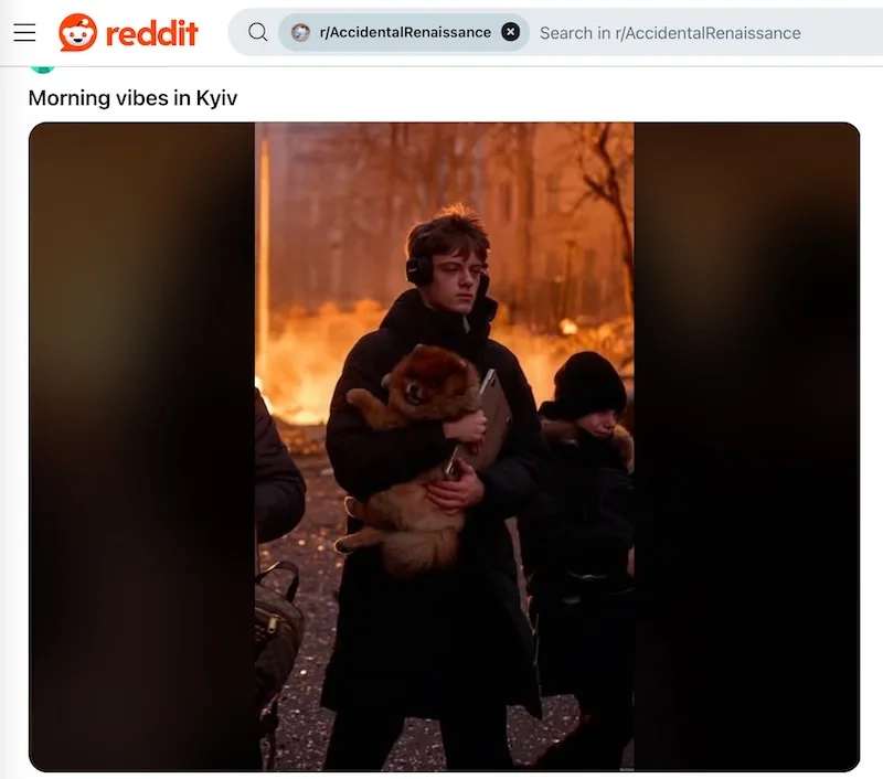 A young man in a dark coat and headphones walks outdoors holding a small fluffy dog while a large fire burns in the…