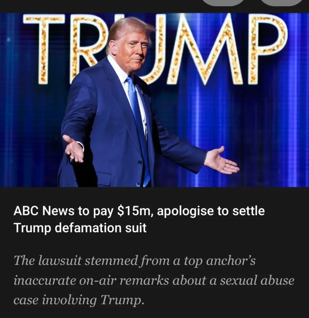 A photo of Donald Trump in a blue suit with arms outstretched, standing in front of a blue curtain with the word 'TRUMP' in…