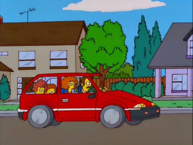 The image shows Homer Simpson driving a red car with his family—Marge, Bart, and Lisa—in the backseat. The car is a compact…