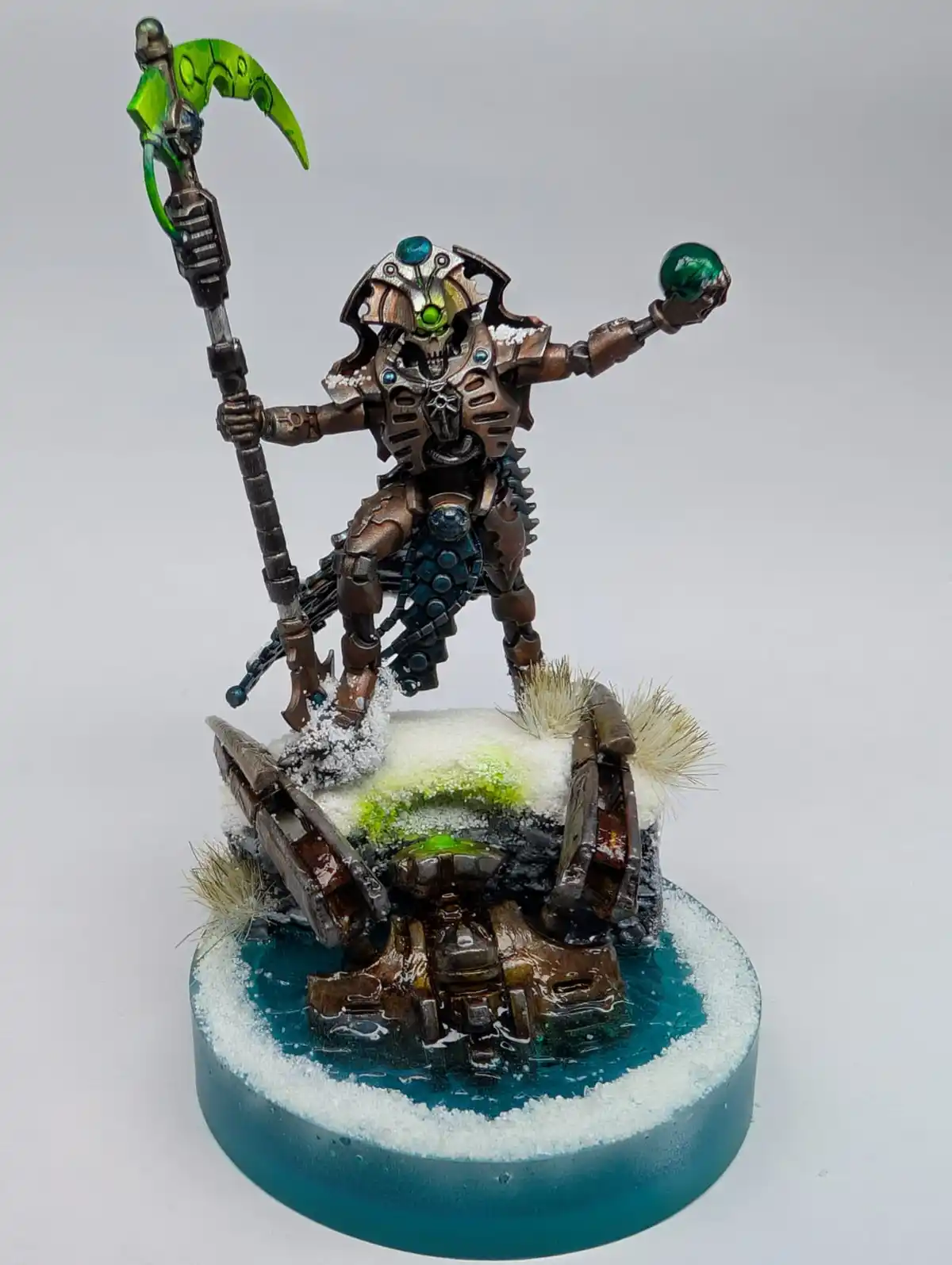 A heavily detailed, custom-painted miniature of a biomechanical warrior with glowing green eyes and a green-bladed weapon…