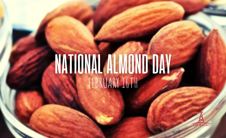 A close-up photo of a glass bowl filled with whole, brown-skinned almonds. Overlaid white text reads 'NATIONAL ALMOND DAY'…