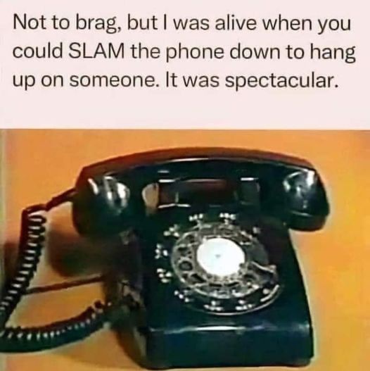 A vintage black rotary telephone with its handset resting on the base, set against a plain orange background. The overlaid…
