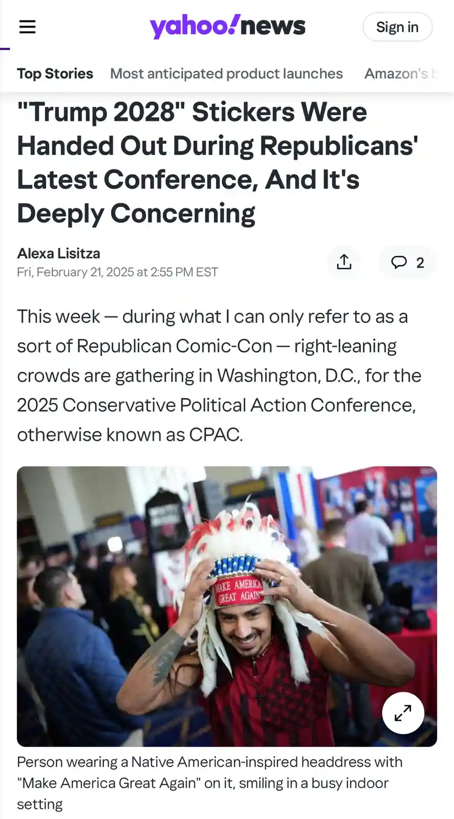 A man smiles while adjusting a Native American-inspired headdress that has a red band with the text 'Make America Great…