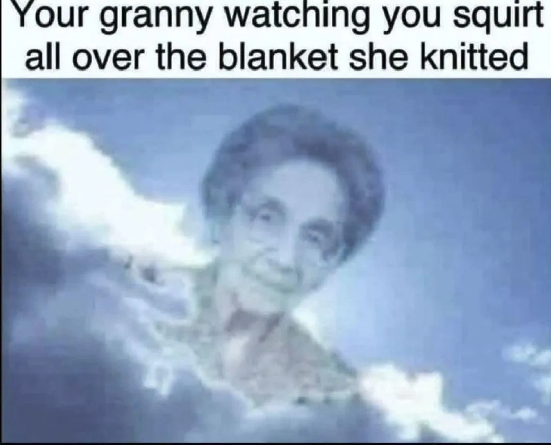 A blurry, blue-tinted image of an elderly woman with short dark hair, smiling faintly while surrounded by clouds, evoking a…