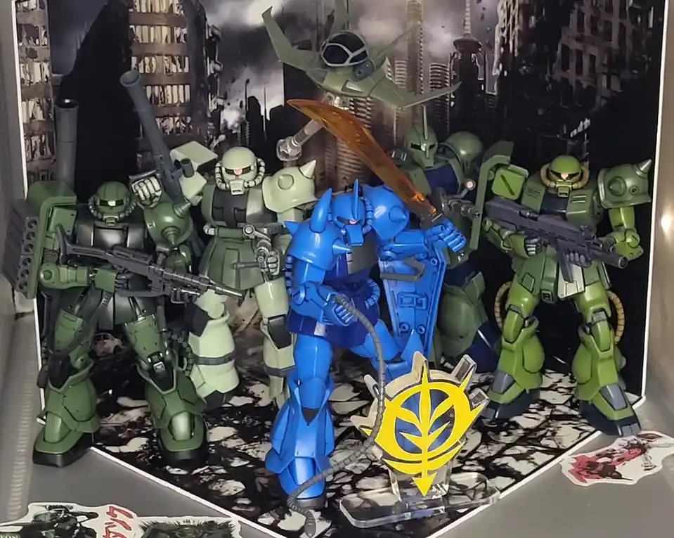 A display of green mobile suits surrounds a central blue mobile suit holding a large sword, with a yellow Zeon symbol on a…