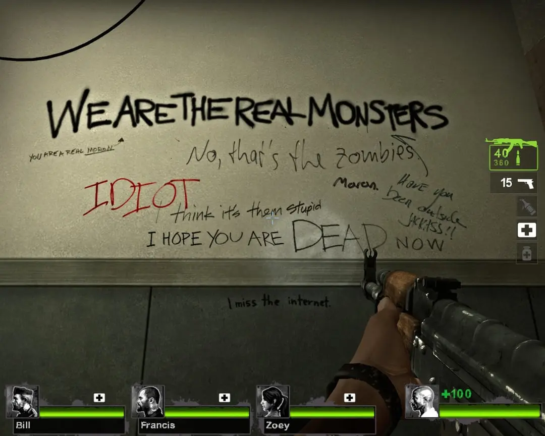A first-person shooter game screenshot showing a wall covered in graffiti. The largest text reads 'WE ARE THE REAL MONSTERS'…