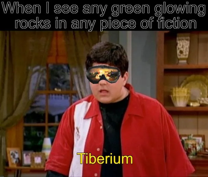 A still image of a young man in a red jacket with a black turtleneck, wearing large, dark goggles that reflect a fiery…