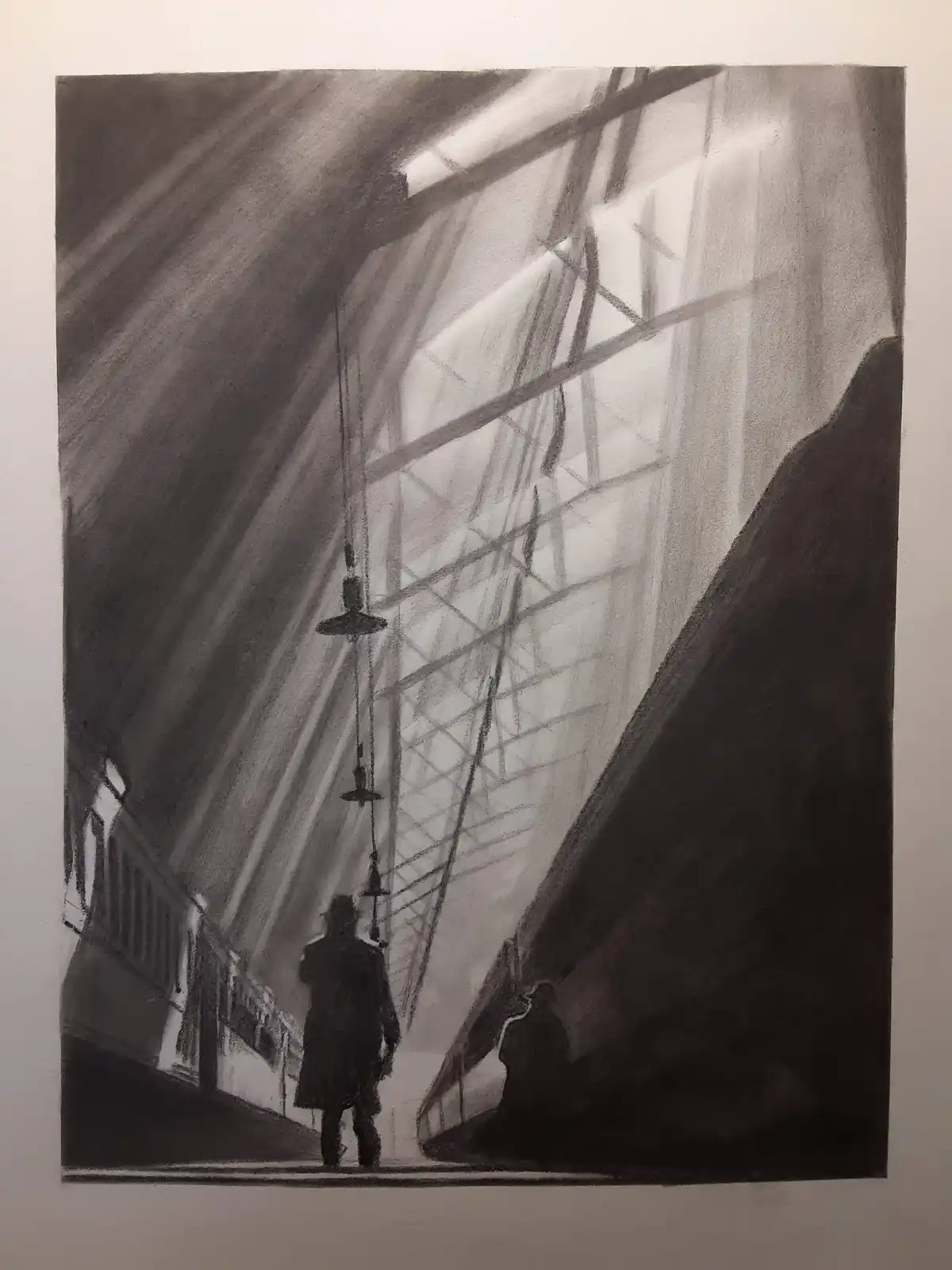 A charcoal drawing depicts a dimly lit, atmospheric train station with two silhouetted figures walking between platforms…