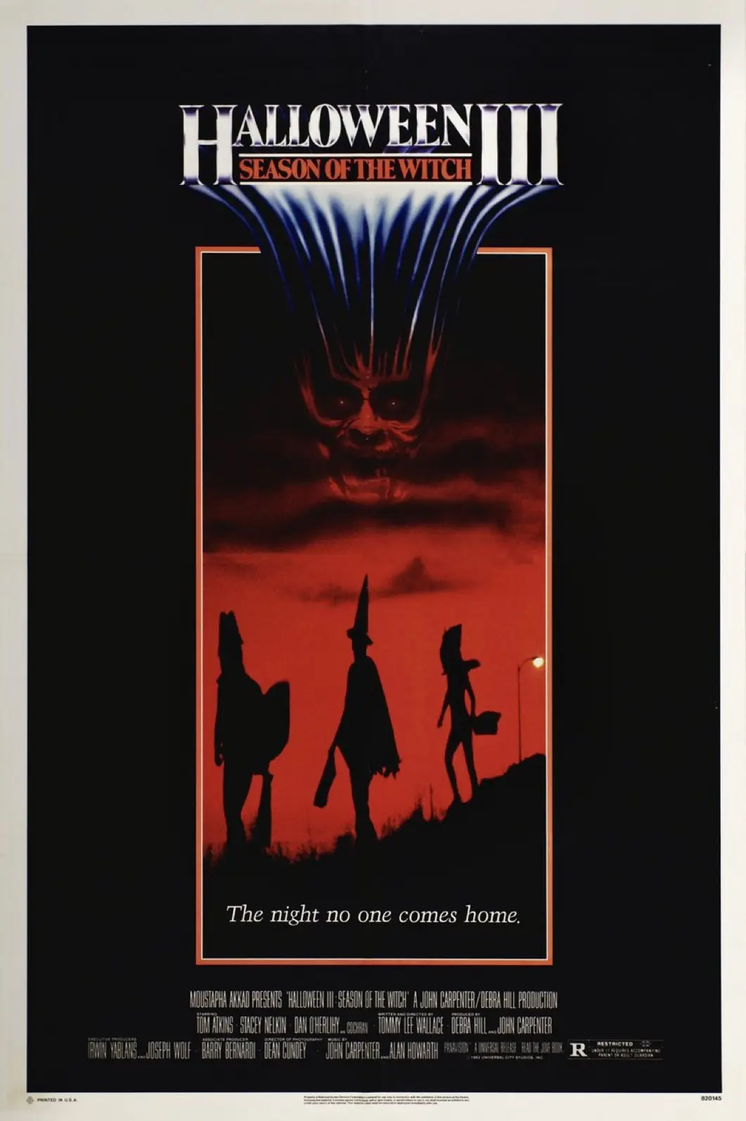 This is the original movie poster for 'Halloween III: Season of the Witch,' featuring a large, menacing skull-like face with…