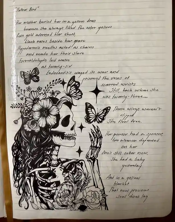 A black-and-white ink drawing on lined notebook paper depicts a skeletal woman with long hair, flowers, and butterflies. The…