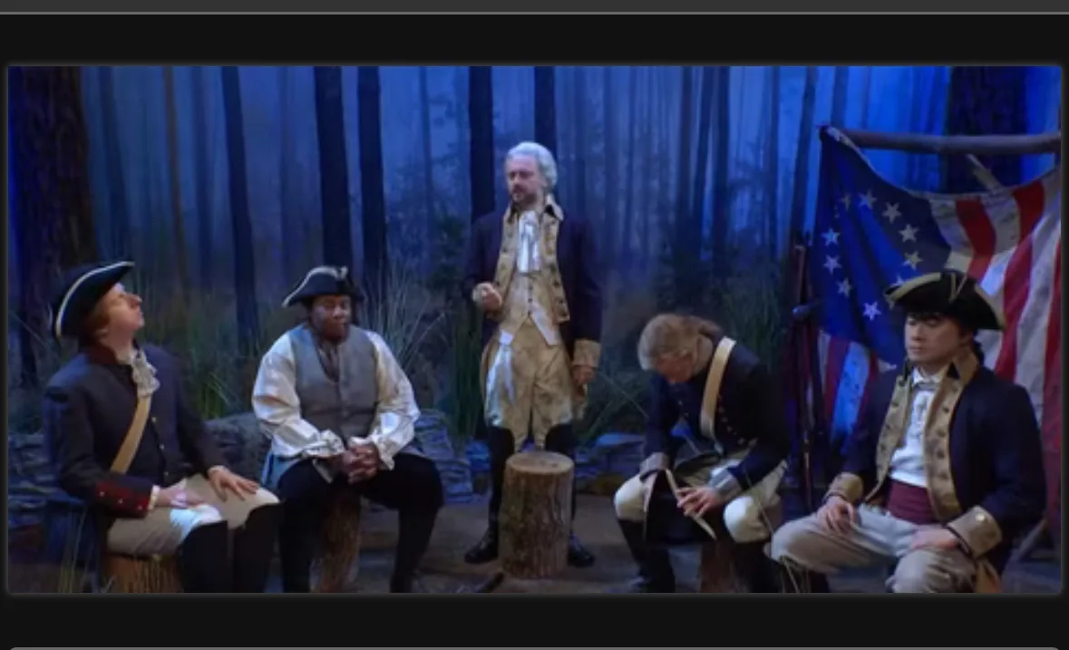 Five men dressed in colonial-era American military uniforms sit or stand in a forest setting, with one man standing and…