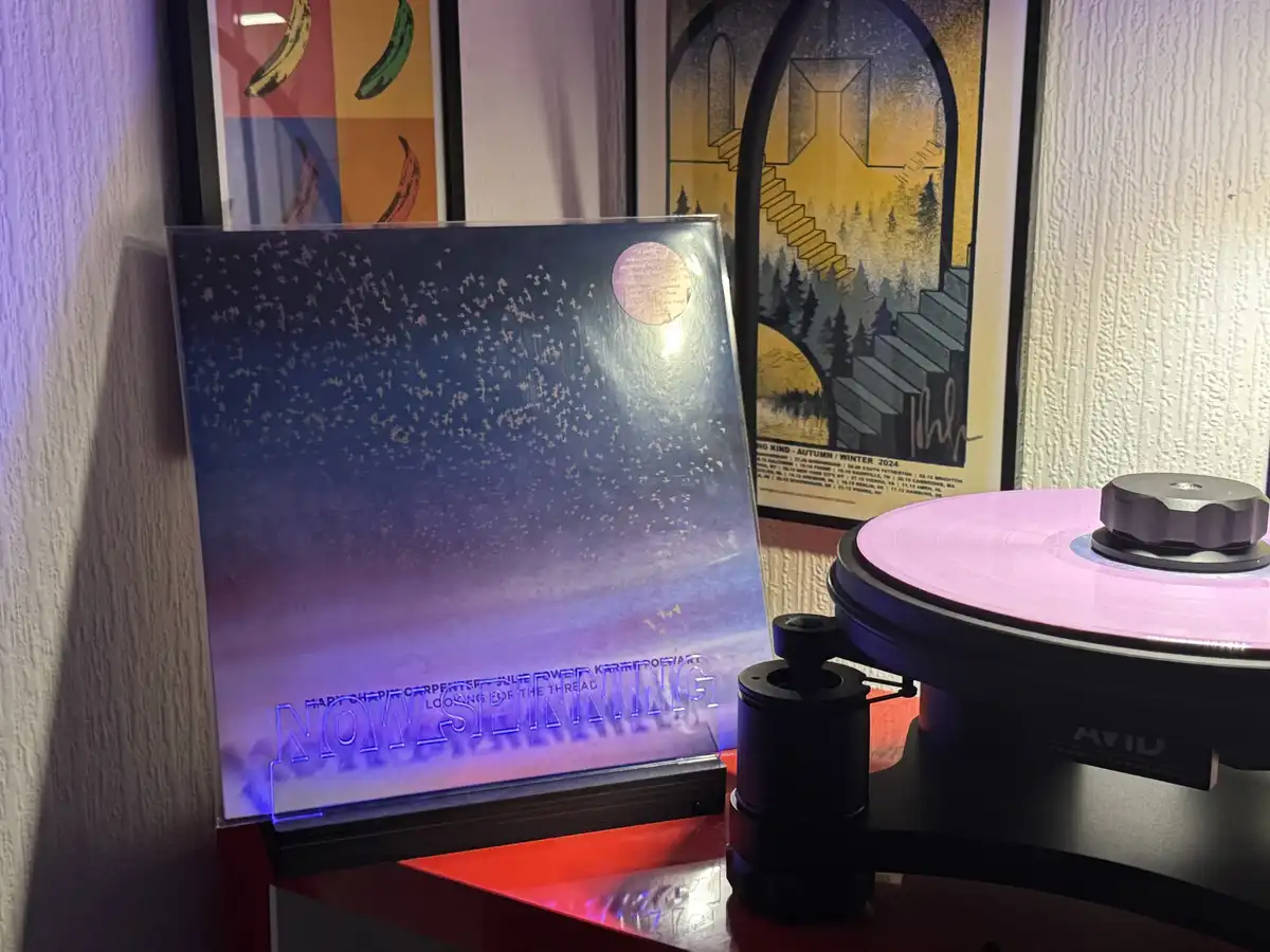A vinyl record player with a pink record spins on the right, while a transparent album cover for 'Harpers Bizarre - Looking…