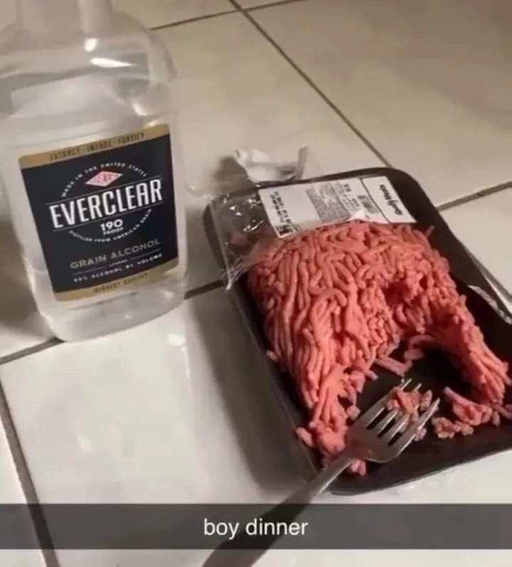 A bottle of Everclear 190 grain alcohol sits next to a package of raw ground meat on a tiled floor, with a fork stuck in the…