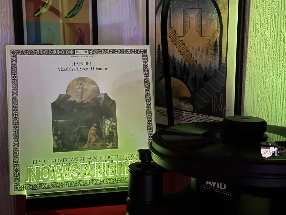 A vinyl record player with a record on it sits next to a classical music album cover for Handel's 'Messiah: A Sacred…