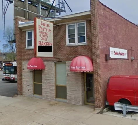A brick building with a red awning and a sign that reads 'Swiss Pastrries WEDDING & PARTY CAKES BAKERY', with the word…