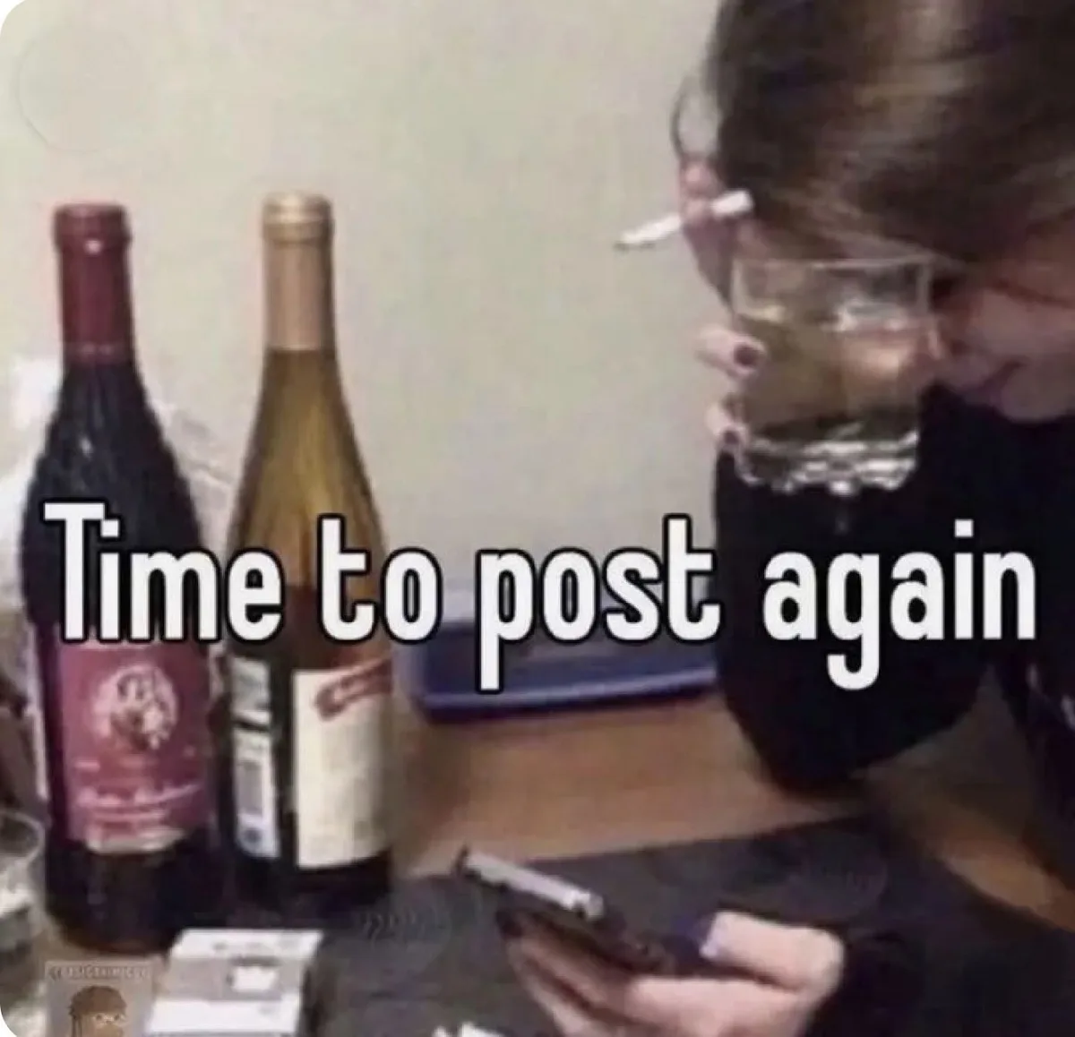 A person with dark hair, holding a glass of liquid to their mouth, has a cigarette balanced on their forehead. Two wine…