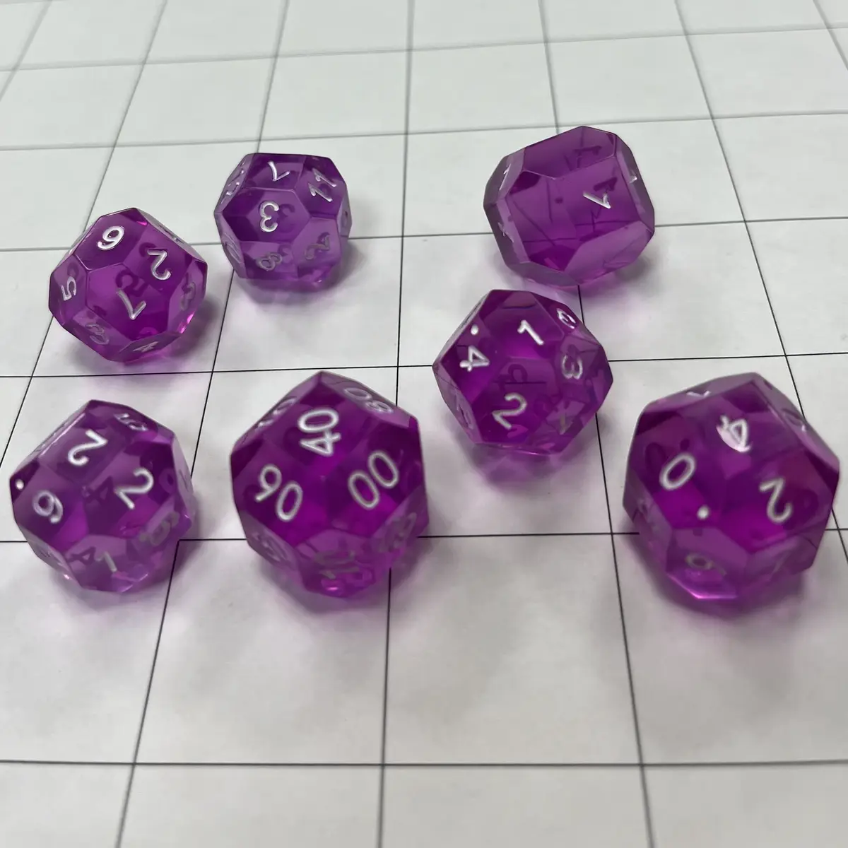 Seven translucent purple polyhedral dice are scattered on a white gridded surface, each showing the number '00' on their…
