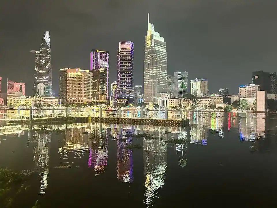 A nighttime cityscape with illuminated skyscrapers reflected in a calm body of water, overlaid with the text 'i'm not lazy…